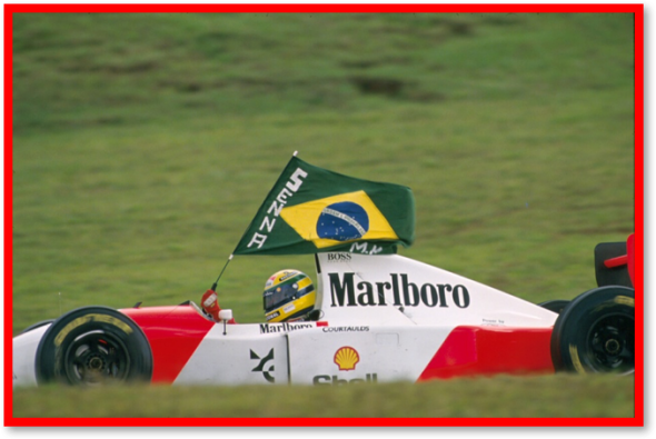 Ayrton Senna in his race car waving the Brazilian Flag : It is believed that the late legend was a patriot at heart, a philanthropist, a genuinely good hearted person. In early 1994, Ayrton Senna confided in his sister a plan to create a charitable organisation, one that would invest in social programs and education across Brazil. Senna had a dream to see every child and youth receive quality education. Photo Credit: 93BR_464 Fotógrafo Norio Koike 2008 -06DVD