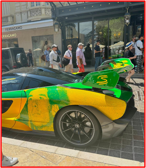 SENNA MAJESTUEUSEMENT ET INTEMPORELLEMENT REPRÉSENTÉ À MONACO. La Cité-État va jusqu'au bout de la symbolique du marbre pour rendre hommage à SENNA, le Génie de l'automobile. En plus d'un poster mural géant en gros plan sur le circuit principal, une parade très particulière de six véhicules autrefois pilotés par lui en l’honneur du grand champion brésilien… Devinez Quoi ? Vous ne trouverez jamais ! !! C'est le sourire d'une oreille à l’autre, l’étincelle dans l'âme que notre éditorial découvre qu'au cœur de Monaco, pour couronner tout, McLaren a dévoilé une monoplace en hommage aux couleurs du casque d'Ayrton Senna : (emblème du Drapeau Brésilien) créé spécifiquement pour le Grand Prix de Monaco. Avec six victoires à Monaco : cinq pour l'écurie britannique, SENNA "The King of Monaco " était dans tous les esprits le dimanche 26 mai 2024, et restera gravé à jamais dans l'histoire de la Formule 1. The Bridge MAG. Image